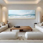 Modern living room with white sofas, a wooden coffee table, and a large beach scene painting on the wall.
