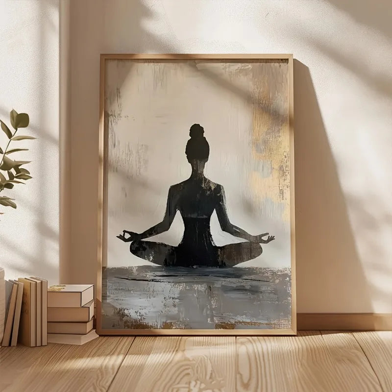 Modern salon artwork of a meditating figure on a textured background, placed on a wooden floor with books and a plant.