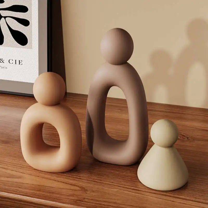Three ceramic figures on a wooden surface with a blurred background
